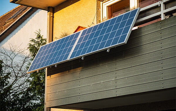 Balkonkraftwerk mit zwei Photovoltaik-Paneelen, die am Balkon befestigt sind