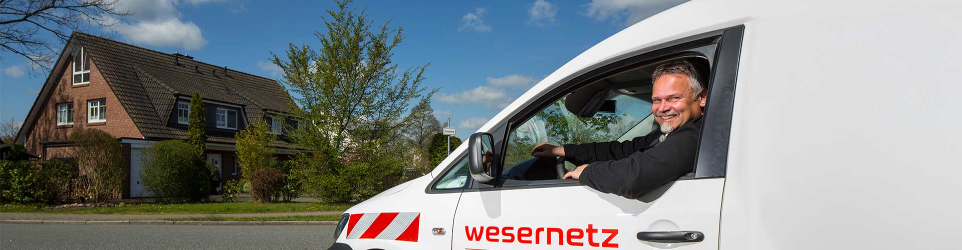 Ein Mitarbeiter lächelt nach einem erfolgreichen Netzanschluss aus seinem Auto