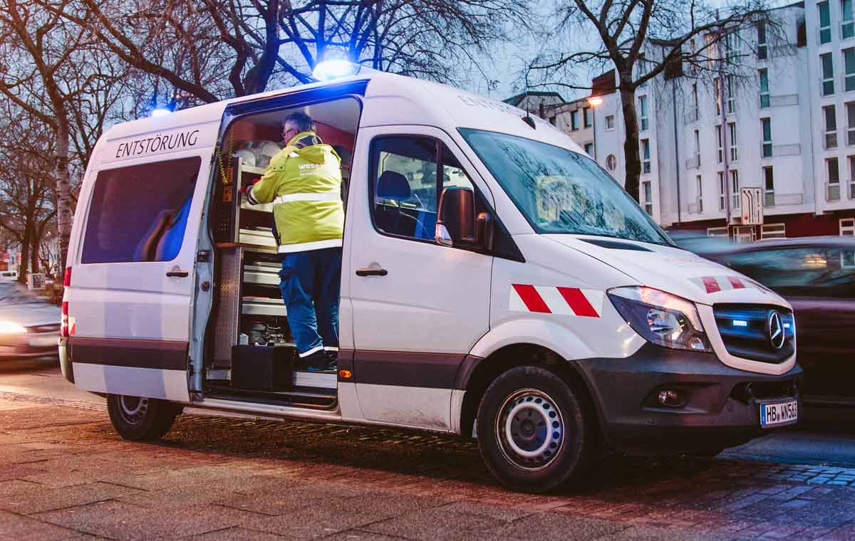 Ein Wagen des Entstörungsdienstes parkt mit angeschaltetem Blaulicht an einer Straße