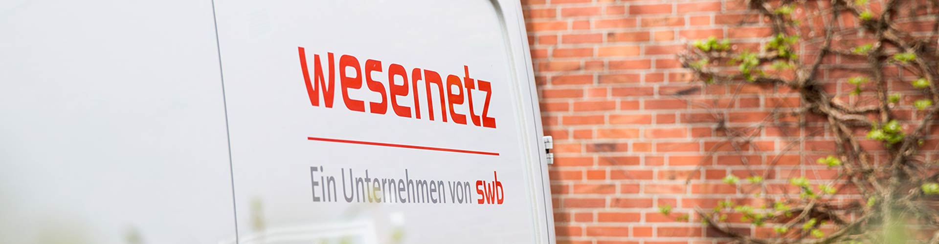 Auf einem weißen Transporter ist das rote Logo von wesernetz gedruckt 