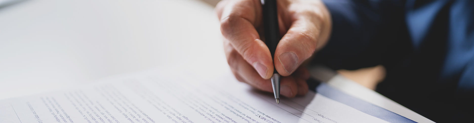 Eine Person unterschreibt eine Compliance-Vereinbarung