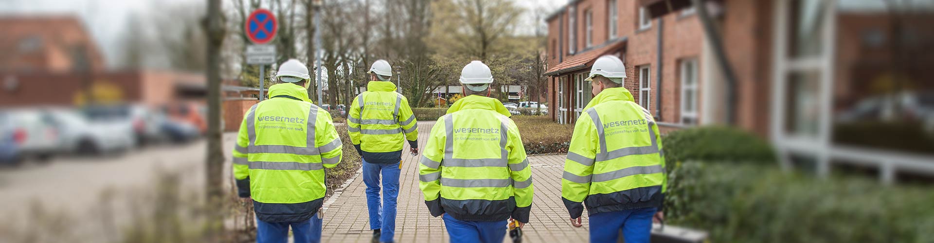 Vier Mitarbeiter von wesernetz laufen durch eine Straße in Stuhr, einer der Gemeinden in denen wesernetz aktiv ist