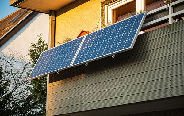 Balkonkraftwerk mit zwei Photovoltaik-Paneelen, die am Balkon befestigt sind