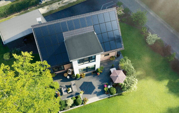 Drohnenaufnahme eines Hauses mit Solarzellen auf dem Dach
