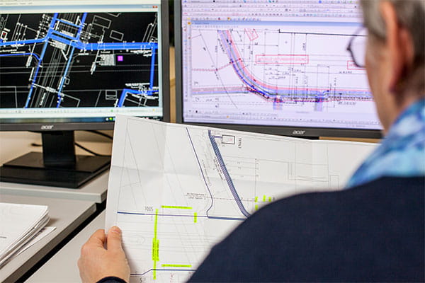 Eine Mitarbeiterin betrachtet Baupläne 