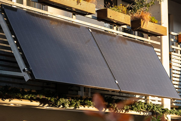 Auf zwei, an einem Balkon befestigte, Solar-Panele scheint Sonne