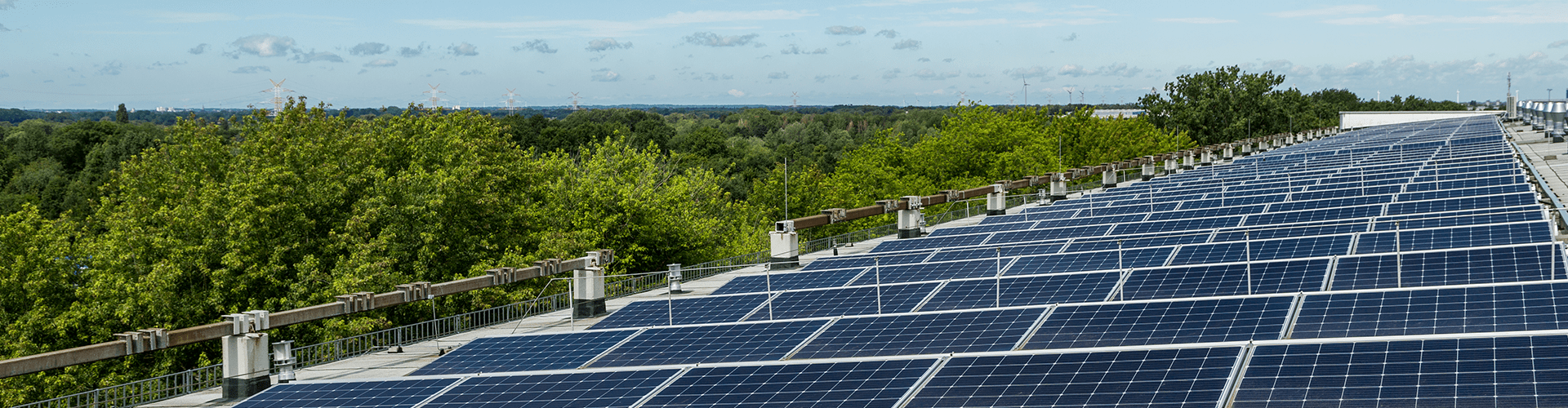 Eine PV-Anlage auf einem Gebäude mit Bäumen im Hintergrund