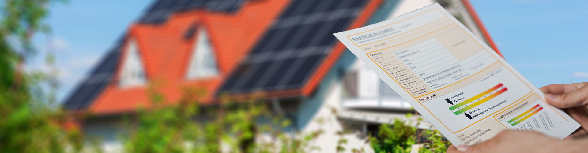 Eine Person hält einen Energieausweis vor sich, im Hintergrund ist ein Privathaus mit PV-Anlage