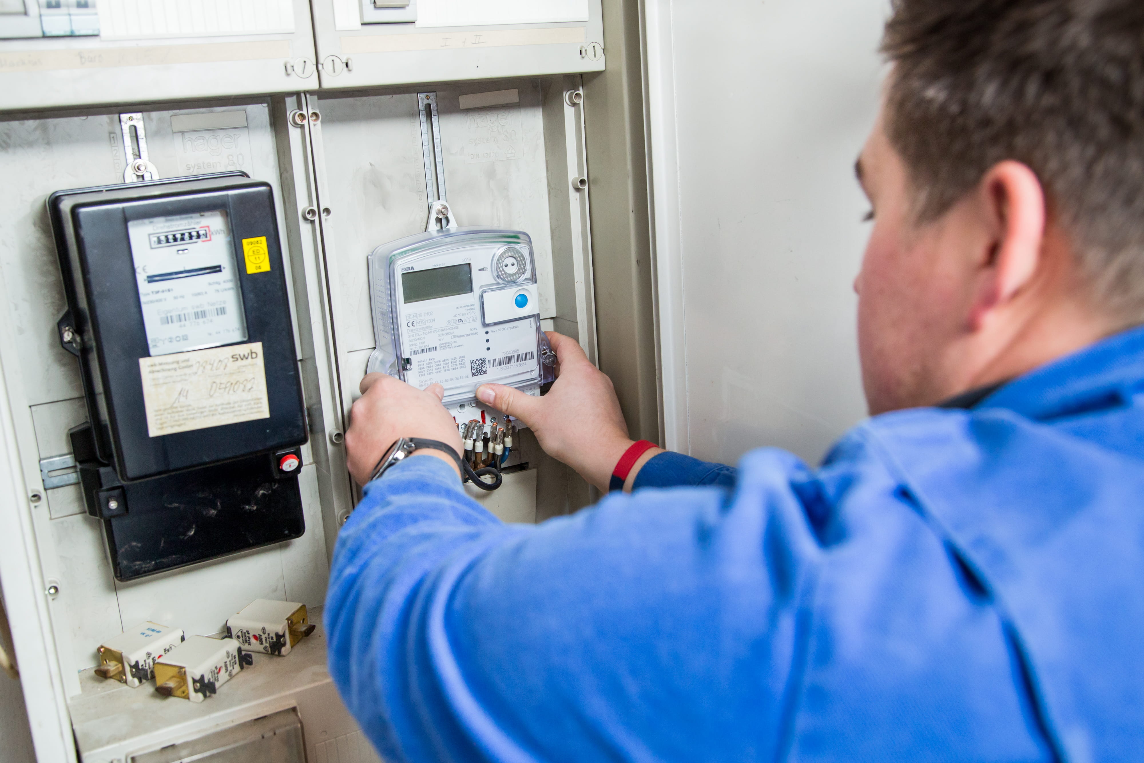 Installateur richtet eine moderne Messeinrichtung im Stromzählerschrank ein