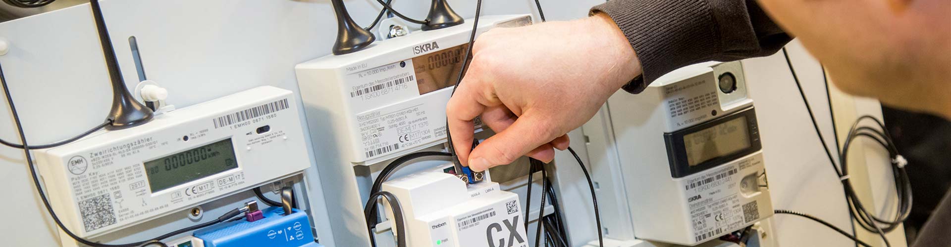 Ein Mitarbeiter verbindet die Kabel eines intelligenten Messsystems