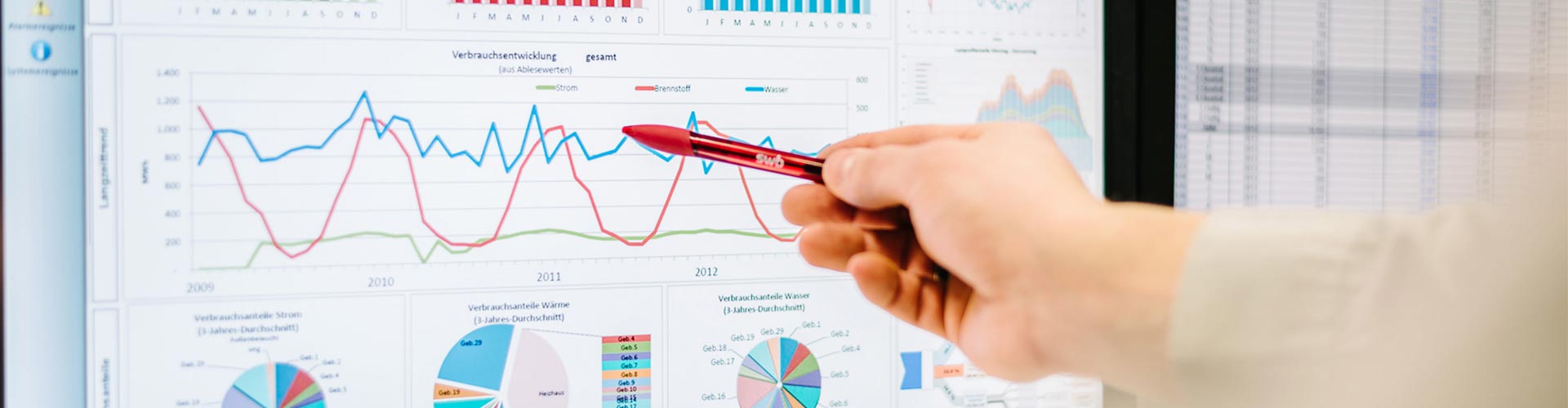 Eine Person deutet mit einem roten Stift auf eine Statistik