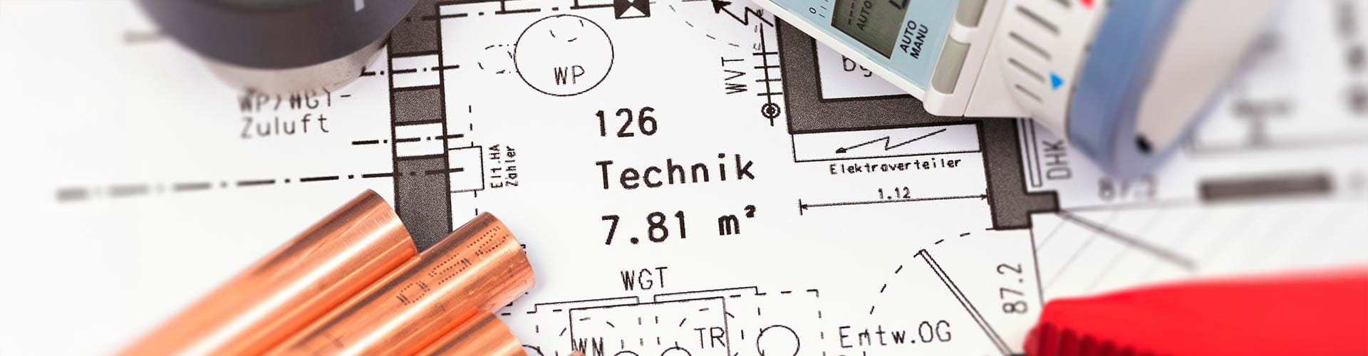 Ein Bauplan mit Werkzeug und Einbaumaterial drumherum 