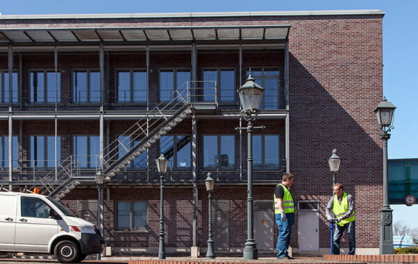 Wesernetz-Mitarbeiter im Gespräch vor einem Backsteingebäude