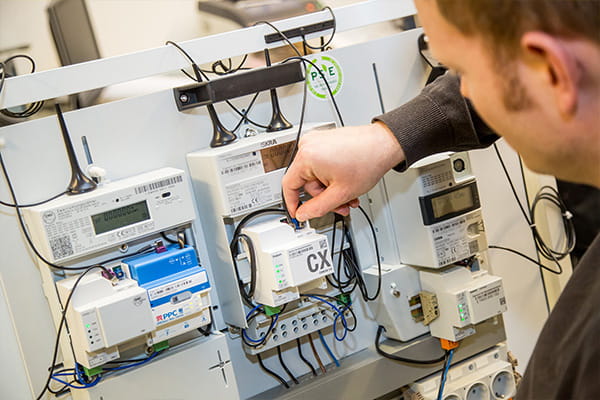 Ein Mitarbeiter verkabelt einen Smart Meter und eine moderne Messeinrichtung
