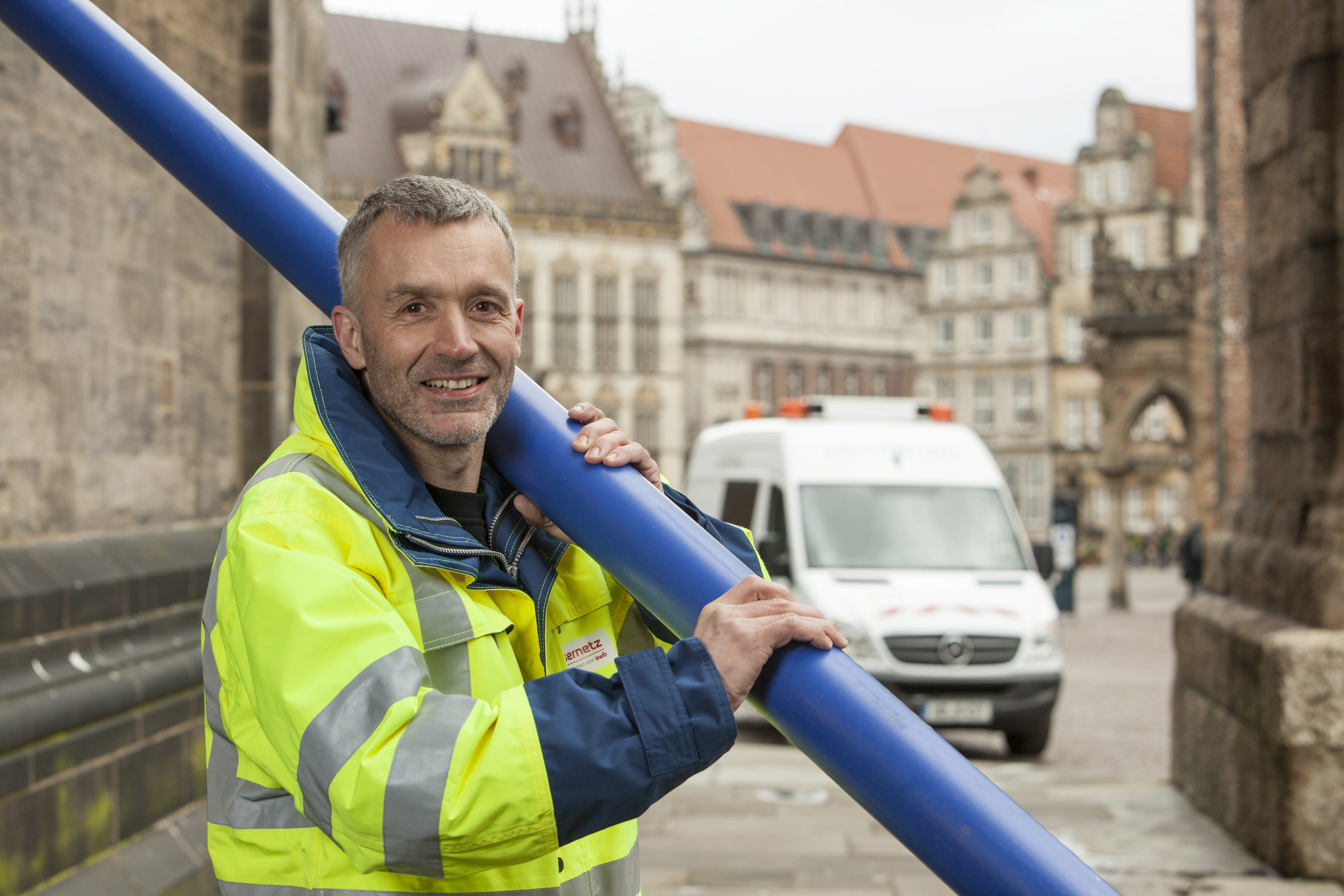 Portrait eines Mitarbeiters mit einem Rohr in der Hand