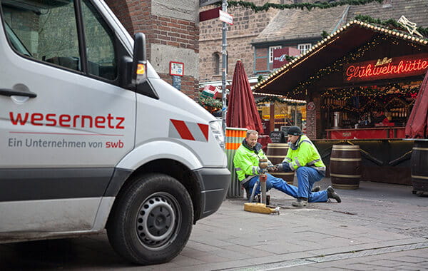 Zwei Mitarbeiter montieren ein Standrohr für befristeten Wasseranschluss